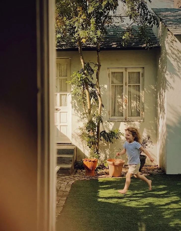 Enfant jouant dans un jardin, lumière dorée